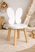 Silla infantil KiddoButterfly blanca con patas de madera natural y respaldo en forma de mariposa, ideal para habitación infantil estilo cozy.